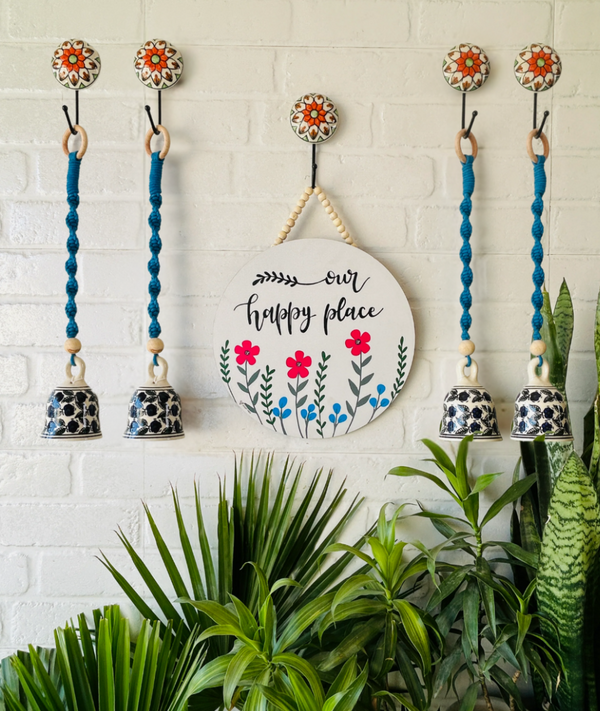 Our happy place wall set up with four blue macrame bells  and ceramic hooks