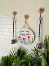 Our happy place wall set up with two blue macrame bells